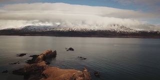 东部Eskifjordur冰岛。无人机在低云中飞过峡湾