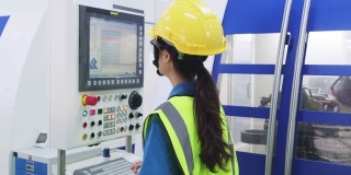 工厂生产线上戴防护安全帽和眼镜的女工。在工业工厂的高科技机器上操作的女孩有自信和微笑的脸。