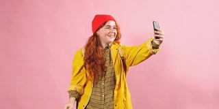 一名身穿黄色斗篷的红发女孩在Skype上与朋友交流