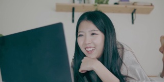 亚洲妇女使用笔记本电脑进行视频会议和在床上工作-股票视频