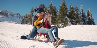 两个微笑的女朋友一起从雪山上滑下来，玩得很开心