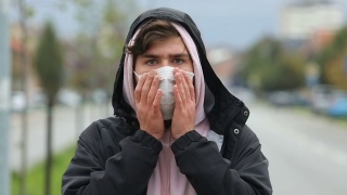 一名青少年在疫情期间戴着口罩的慢镜头视频素材模板下载