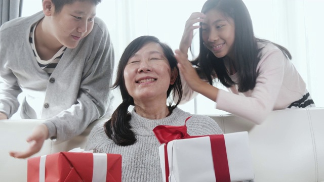 亚洲的孩子会给他们的母亲惊喜，并在母亲节或特别的活动概念送礼物盒给她。