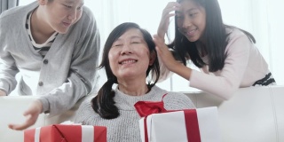 亚洲的孩子会给他们的母亲惊喜，并在母亲节或特别的活动概念送礼物盒给她。