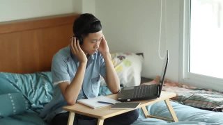 年轻的亚洲人在家里使用笔记本电脑学习视频素材模板下载