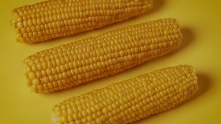 美味的煮甜玉米在黄色的背景视频素材模板下载