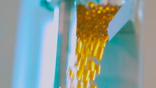 在输送明胶胶囊生产线上，许多黄色明胶胶囊在生产中视频素材模板下载