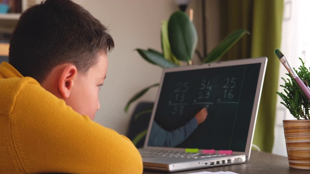 6-7岁可爱的孩子从电脑学习数学。学习在家里。