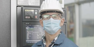 工作新常态。肖像男工程师身穿防护服、安全帽、护目镜和防护面罩，在工业工厂工作时保护粉尘和新冠肺炎大流行。