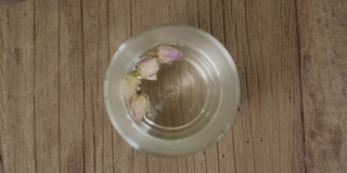 俯视图将开水倒入玻璃壶中冲泡玫瑰花茶