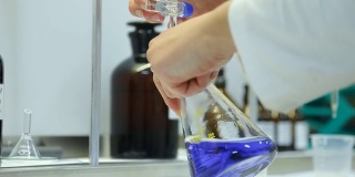 科学实验室中的化学实验室研究。化学家手里拿着一个玻璃烧瓶