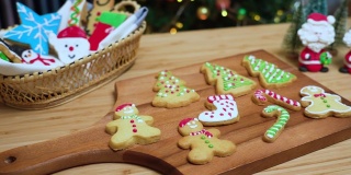 在摄影小车上可以看到:自制的糖衣圣诞饼干，红鞋，雪人，姜饼，圣诞树。有些饼干放在木盘子里，有些放在木架子上。黄色圣诞灯，圣诞装饰树和装饰品。