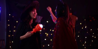 两个亚洲女人在跳舞。万圣节派对上有两个女人。朋友们在万圣节派对上玩得很开心。