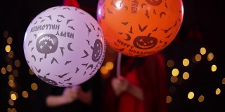 万圣节前夕穿着女巫服装并拿着气球的亚洲妇女。