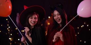 万圣节前夕穿着女巫服装并拿着气球的亚洲妇女。