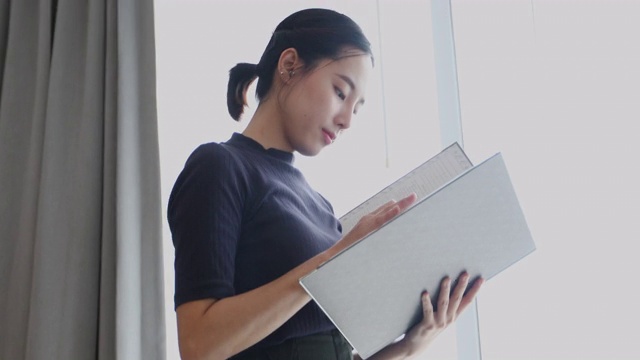 亚洲女性持有文件，审查文件在办公室工作