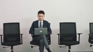 年轻的亚洲求职者坐在椅子上等待面试视频素材模板下载