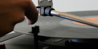 旋转黑胶唱片被一个女人的手关闭。