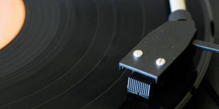 在复古风格的乙烯基唱片播放器上旋转的摇滚音乐乙烯基唱片。一张黑胶唱片的特写。