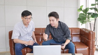 保险代理人向亚洲资深男士介绍如何在家使用笔记本电脑购买健康保险视频素材模板下载