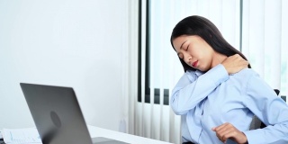 年轻的亚洲商务女性在办公室用笔记本电脑努力工作，因为颈部疼痛而做伸展运动，热身和锻炼的4k视频片段
