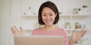 亚洲商务女性使用笔记本电脑进行视频通话，通过网络摄像头进行在线聊天，民族女性在家中进行远程聊天工作，新冠肺炎疫情隔离期间进行在线会议