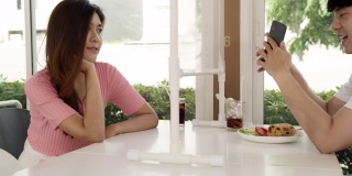 4K超高清多莉拍摄:亚洲美女女招待上菜，并在用餐前将酒精洗手液推送给顾客，以减少被冠状病毒感染的机会。新常态卫生生活理念。
