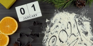为圣诞节和新年准备节日大餐。日历，日期为1月1日。公牛作为2021年新年的象征。平面布局。饼干模具和面粉。橘子和八角。