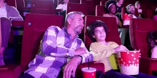 老人和他的孙子在电影院看电影