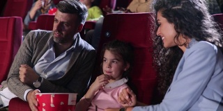 女孩和她的父母在看电影