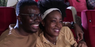 一对非洲裔美国夫妇在看浪漫电影，在电影院玩得很开心