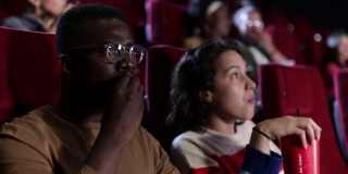 一个女孩和她的非裔美国朋友在电影院看一部严肃的电影