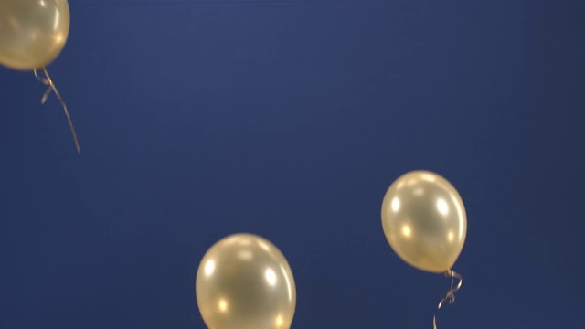 节日装饰-气球-出现在视频作为礼物的节日:情人节，生日，圣诞节，一个节日事件或新年在蓝色背景。