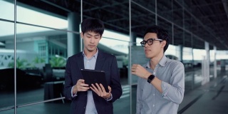 两个商人在外面开会时正在看数字平板电脑