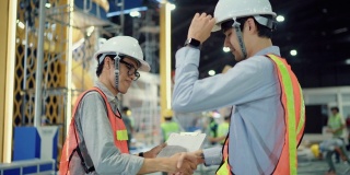 两个工程师在工厂里握手