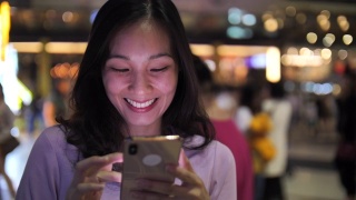 亚洲女性在晚上使用智能手机视频素材模板下载
