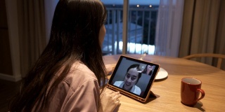 两个亚洲女人在家里通过视频电话聊天，保持社交距离