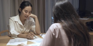两个亚洲女性在家里工作的时候讨论市场营销的场景