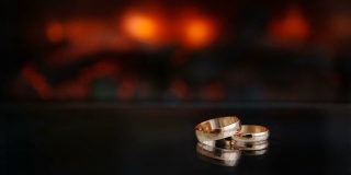 静态的框架两个金戒指从壁炉的火玻璃桌子黑色的黑色背景