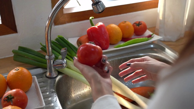 woman washing a fruit or vegetables in kitchen