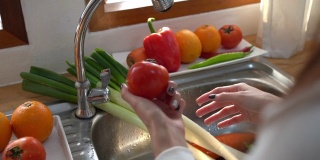 woman washing a fruit or vegetables in kitchen