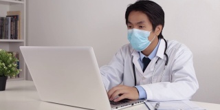 亚洲医生与听诊器使用笔记本电脑在办公室