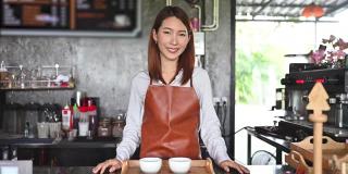 亚洲女咖啡师为顾客提供咖啡。创业的概念