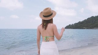 亚洲女性在比基尼走在热带白色沙滩上视频素材模板下载
