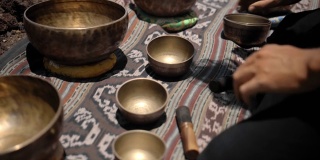 亚洲人在观景山上玩藏人唱铜杯