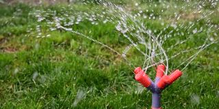 跟着五喷头粉碎机的塑料花园自动喷水装置转动。旋转着向草坪和花坛上的草喷洒。浇水和照顾植物。