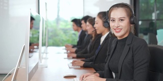 亚洲呼叫中心的女性与不同种族的员工在运营监控室接触或与客户概念交谈