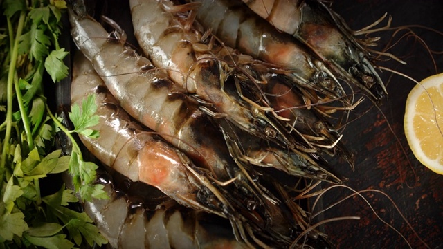 生虾和绿色蔬菜放在砧板上旋转。