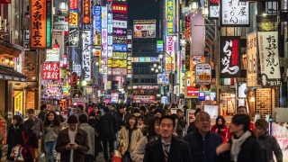 在东京新宿，人群步行在购物街上的一段时间视频素材模板下载