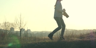 年轻的女摄影师走在田野里